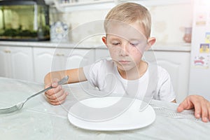 Boy is looking at an empty plate