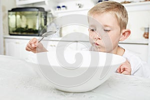 Boy is looking at an empty plate