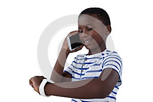 Boy looking at his smart watch while talking on mobile phone