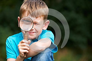 Boy Looking Through Magnifying Glass With Magnified Eye