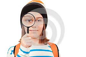 Boy looking through magnifying glass. Schoolboy holding the magnifying glass. Children's interest.