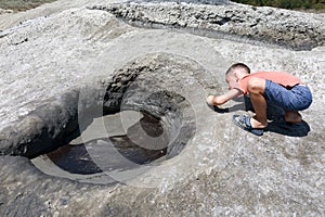 Boy looking at mud pond