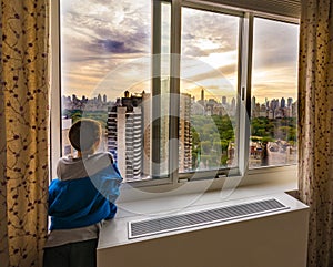 Boy looking at a New York City sunrise