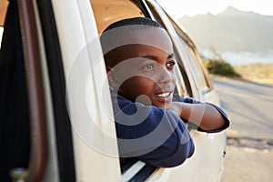 Boy Looking Out Of Car Window On Family Road Trip