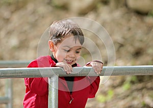 Boy looking over a railing at a bridge