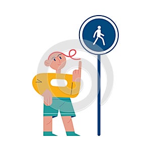 Boy looking at pedestrian zone road sign and memorizing traffic rules