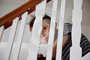 Boy looking scared through the handrail