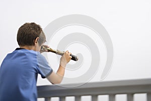 Boy looking through telescope.