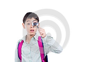 Boy looking thru magnifying glass over white