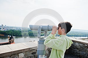 Boy looking at touristic telescope of Bratislava view, Slovakia