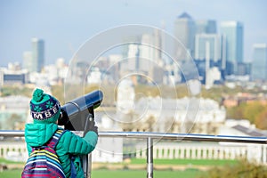 A boy looking into tower viewer at London from Greenwich Park
