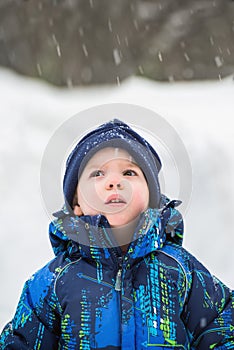 Boy Looking Up in Wonder at Snow Falling