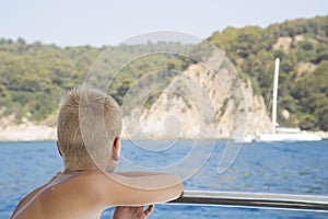 Boy looks from boat on the sea