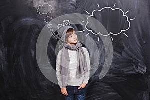 The boy looks at a cloud drawn on the chalkboard