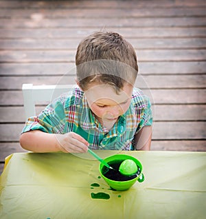 Boy Looks at His Easter Egg in the Green Dye