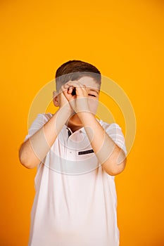 The boy looks like through binoculars. Hands folded