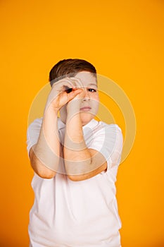 The boy looks like through binoculars. Hands folded