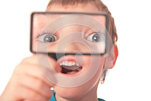 Boy looks through magnifier with surprise