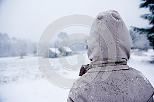 Boy looks out over a wintry landscape