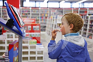 Boy looks at show-windom, bookshop photo