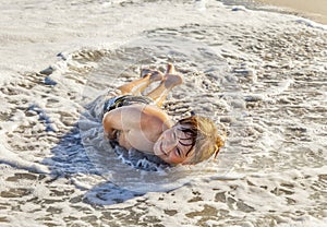 Boy lying at the beach and enjoying the sun