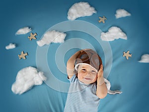 Boy lying on blanket with white clouds