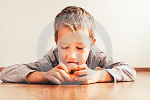 Boy lying down biting an apple, isolating white background, concept of healthy nutrition at home