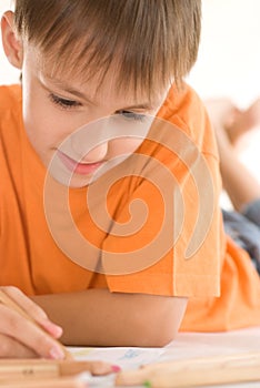 Boy lying and draw