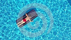 boy lying on inflatable mattress in the swimming pool, aerial view