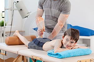 Boy lying on physiotherapy table