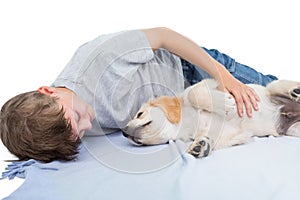 Boy lying with puppy on blanket