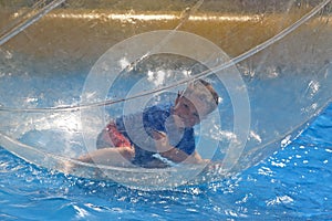 Boy lying in water sphere