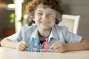 The boy made figures of people from plasticine dad, mother and child, happy smiles on camera ,family relations concept