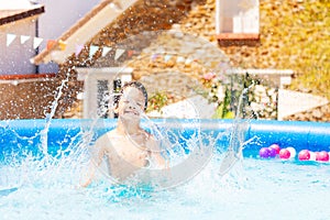 Boy makes big splashes in inflatable swimming pool