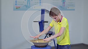 Boy makes experiment with water and copper bowl