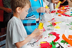 Boy makes flower of tissue paper by stapler