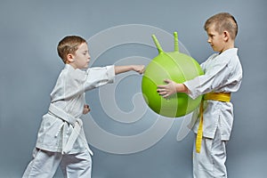 The boy makes a punch on the green ball