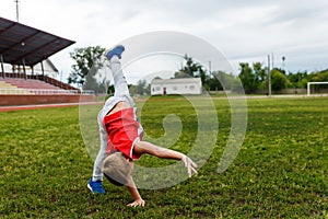 Boy makes a wheel on the grass