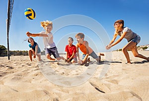 Boy making bump pass during beach volleyball game