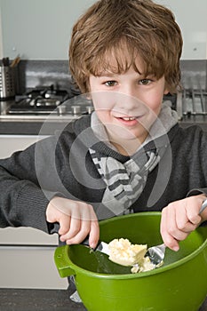 Boy making the dough for the cakes