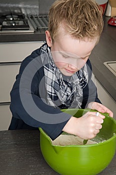 Boy making the dough for the cakes