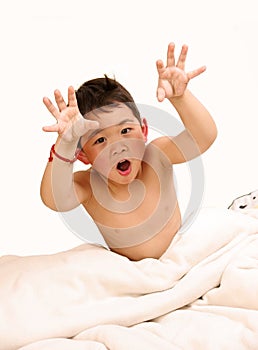 Boy making faces on bed