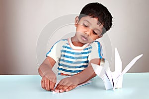 Boy making paper bird