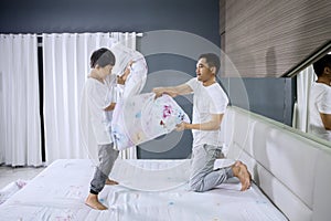 Boy making pillow fight with his father