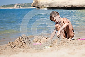 Boy making sand castle on beach