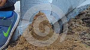 Boy making a sand castle in construction zone