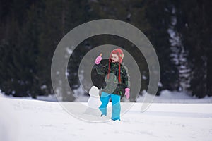 Boy making snowman in wintwr