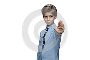 Boy making stop gesture with his palm on whte background.