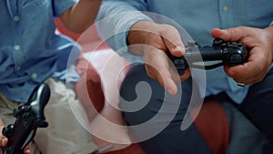 Boy and man hands playing video game with gamepads. Family having fun at home