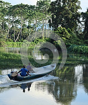 boy maneuvering boat in the river